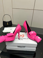 Pink stiletto heels with front bow detail and round button embellishments