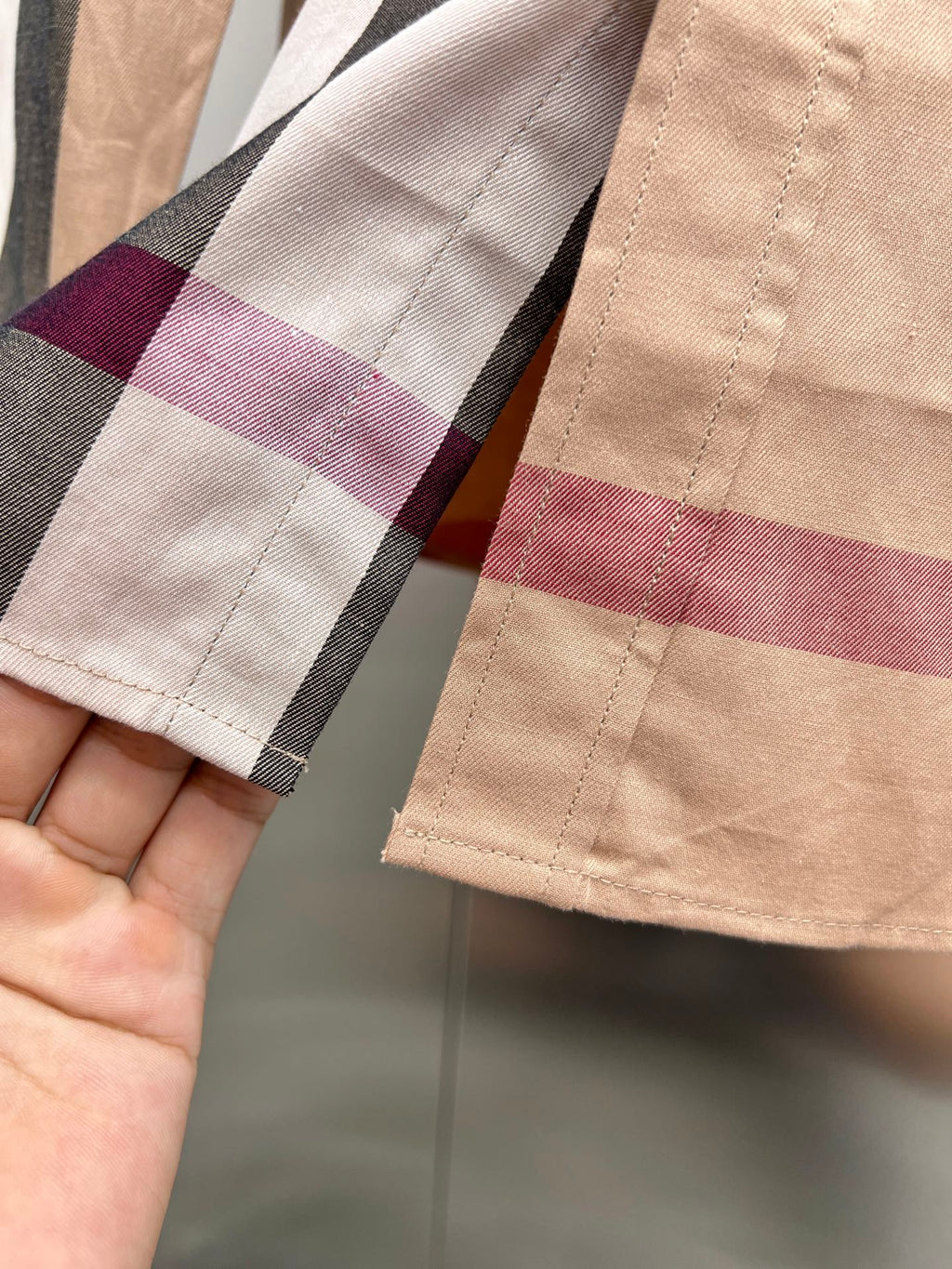 Burberry plaid cuff and sleeve hem on beige check button-up shirt close-up