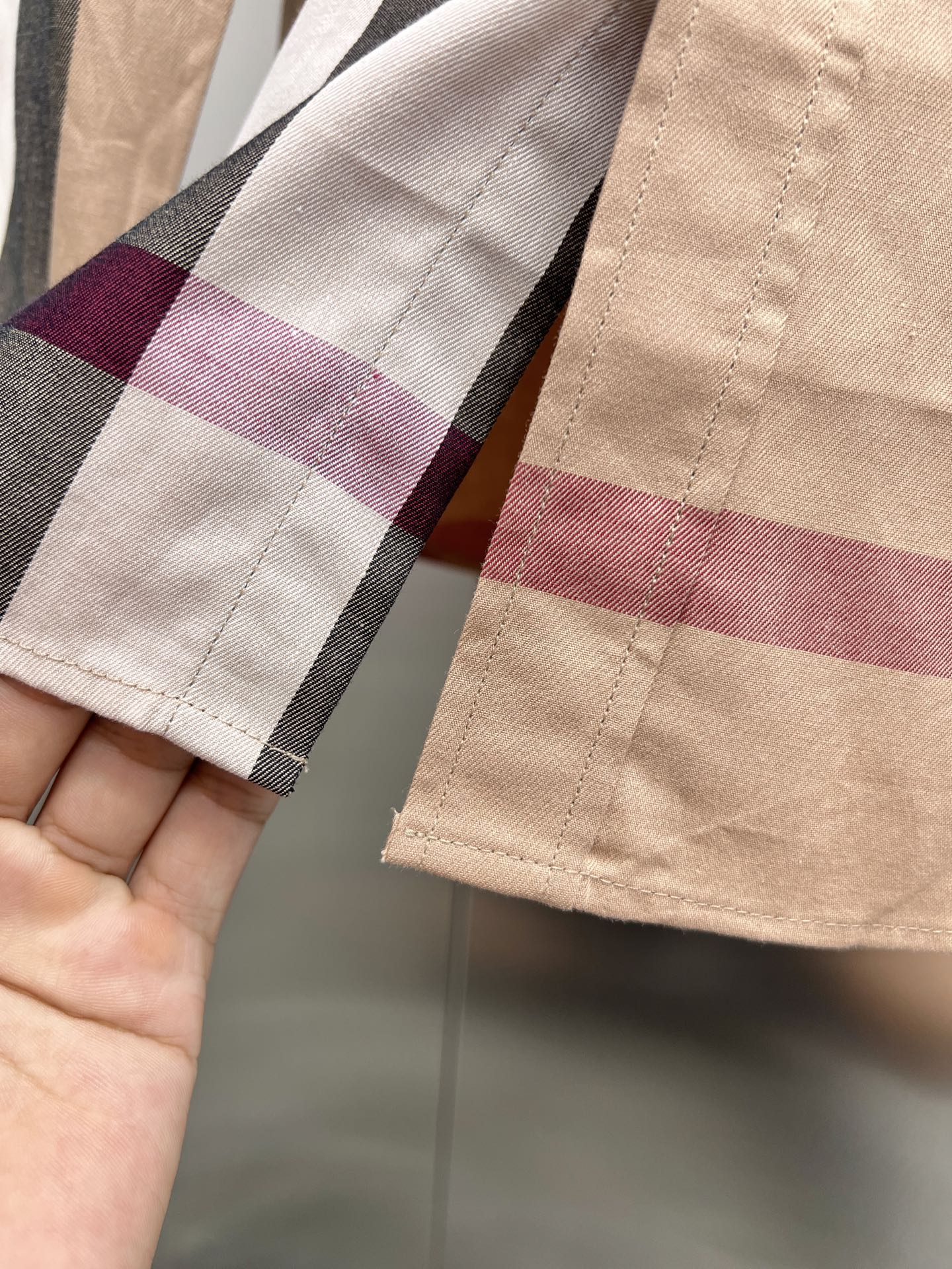 Burberry plaid cuff and sleeve hem on beige check button-up shirt close-up