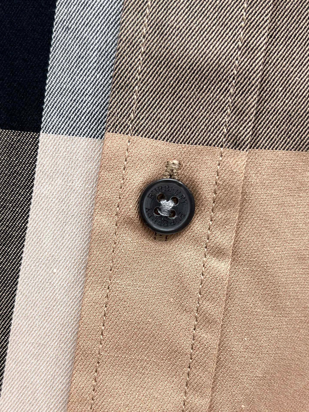 Burberry plaid button detail on beige check button-up shirt close-up