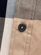 Burberry plaid button detail on beige check button-up shirt close-up