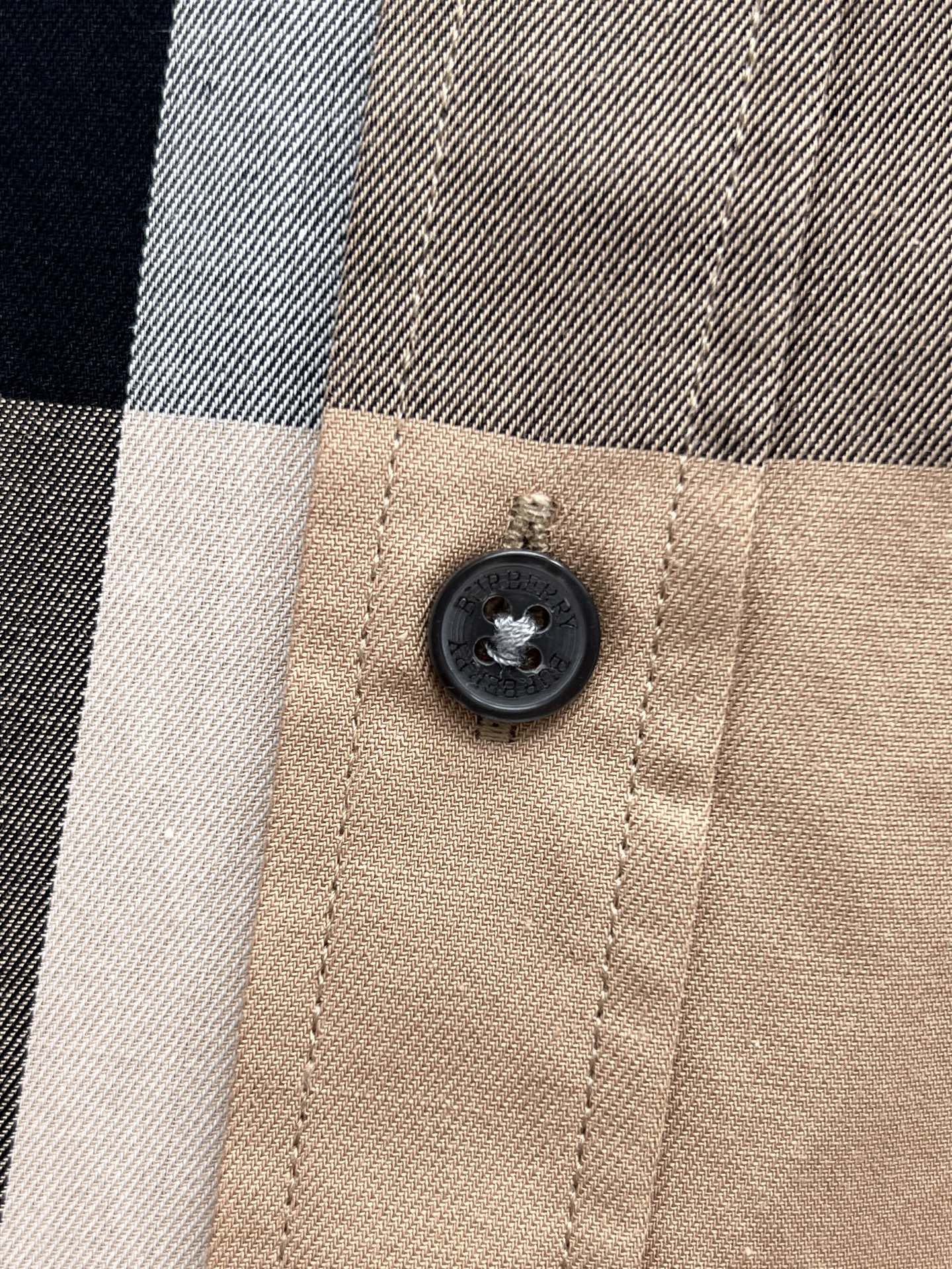 Burberry plaid button detail on beige check button-up shirt close-up