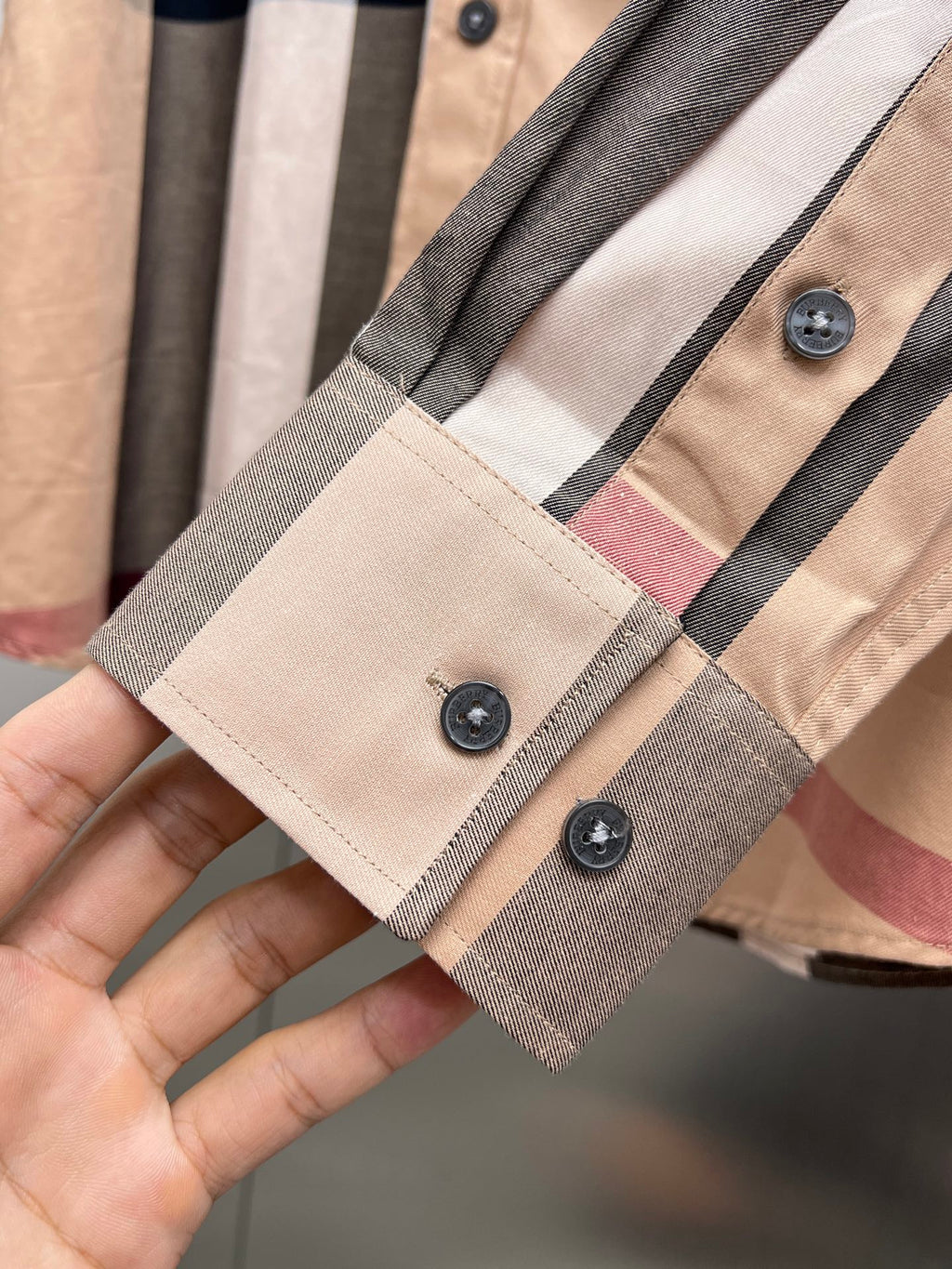 Burberry long-sleeve shirt cuff with dark buttons and plaid trim