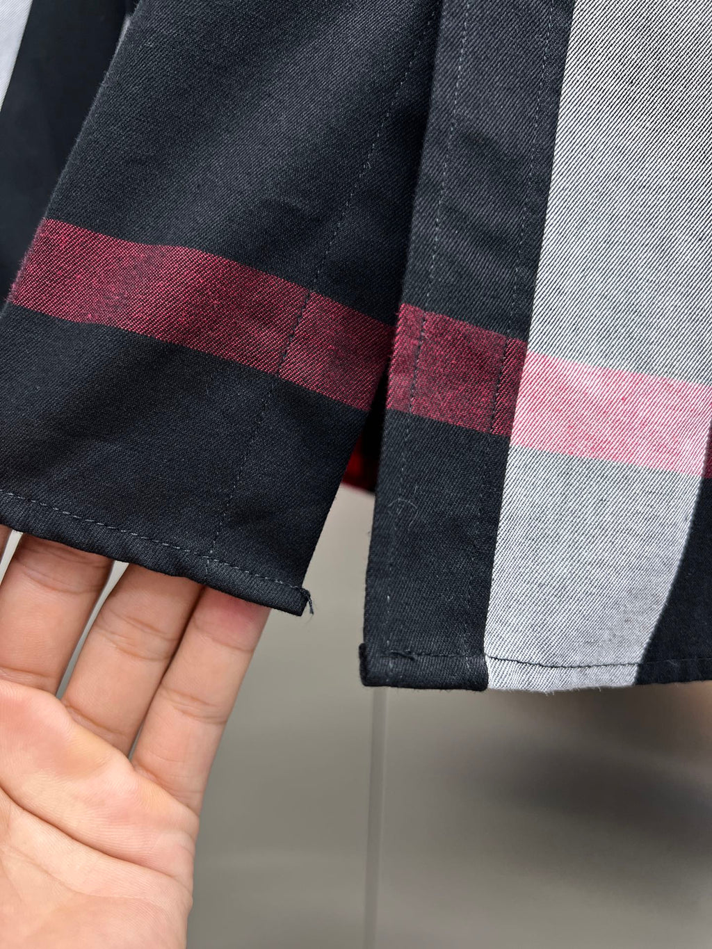 Cuff detail on black, white, and red plaid long-sleeve button-up shirt
