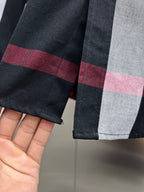 Cuff detail on black, white, and red plaid long-sleeve button-up shirt