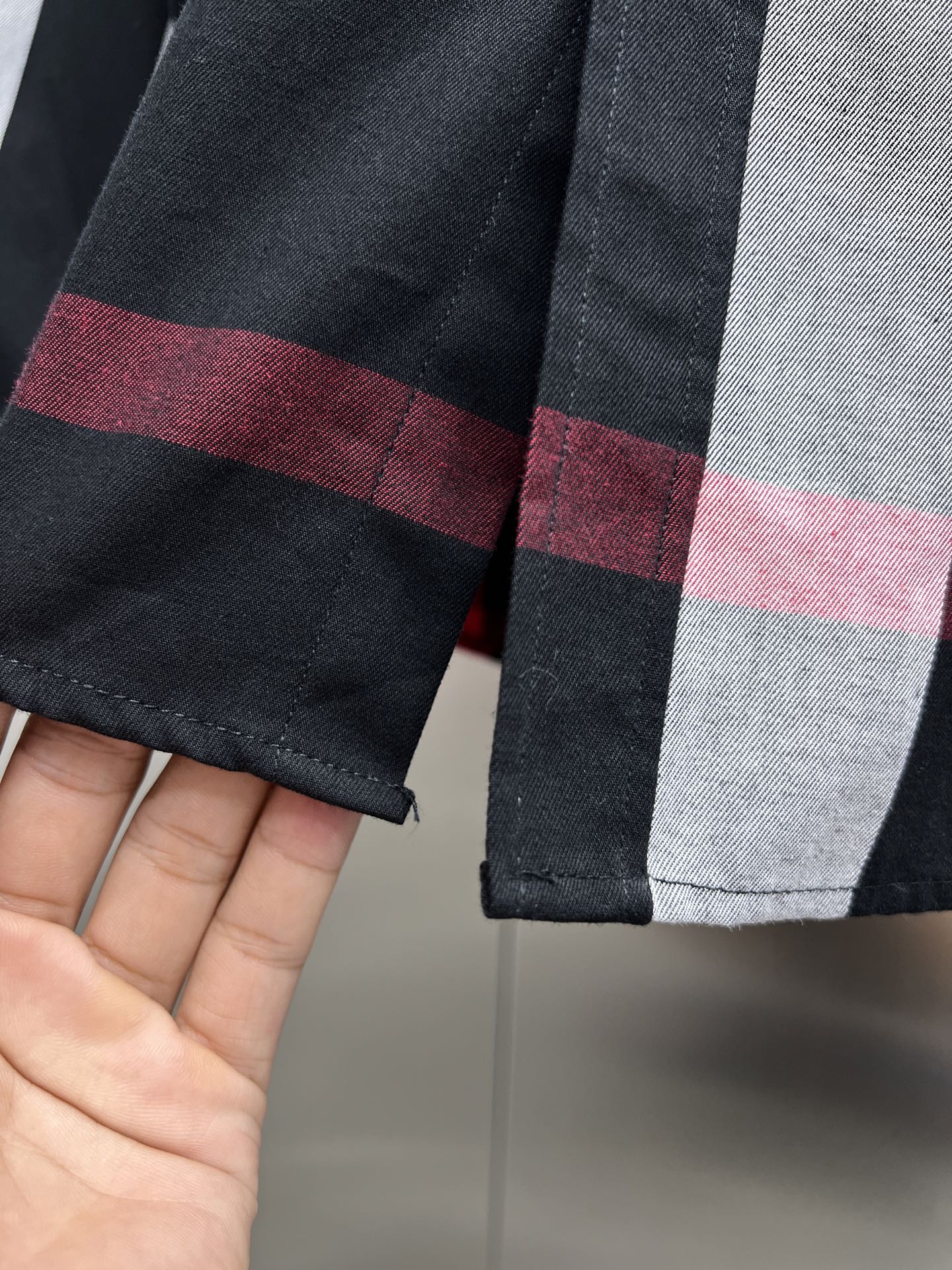 Cuff detail on black, white, and red plaid long-sleeve button-up shirt