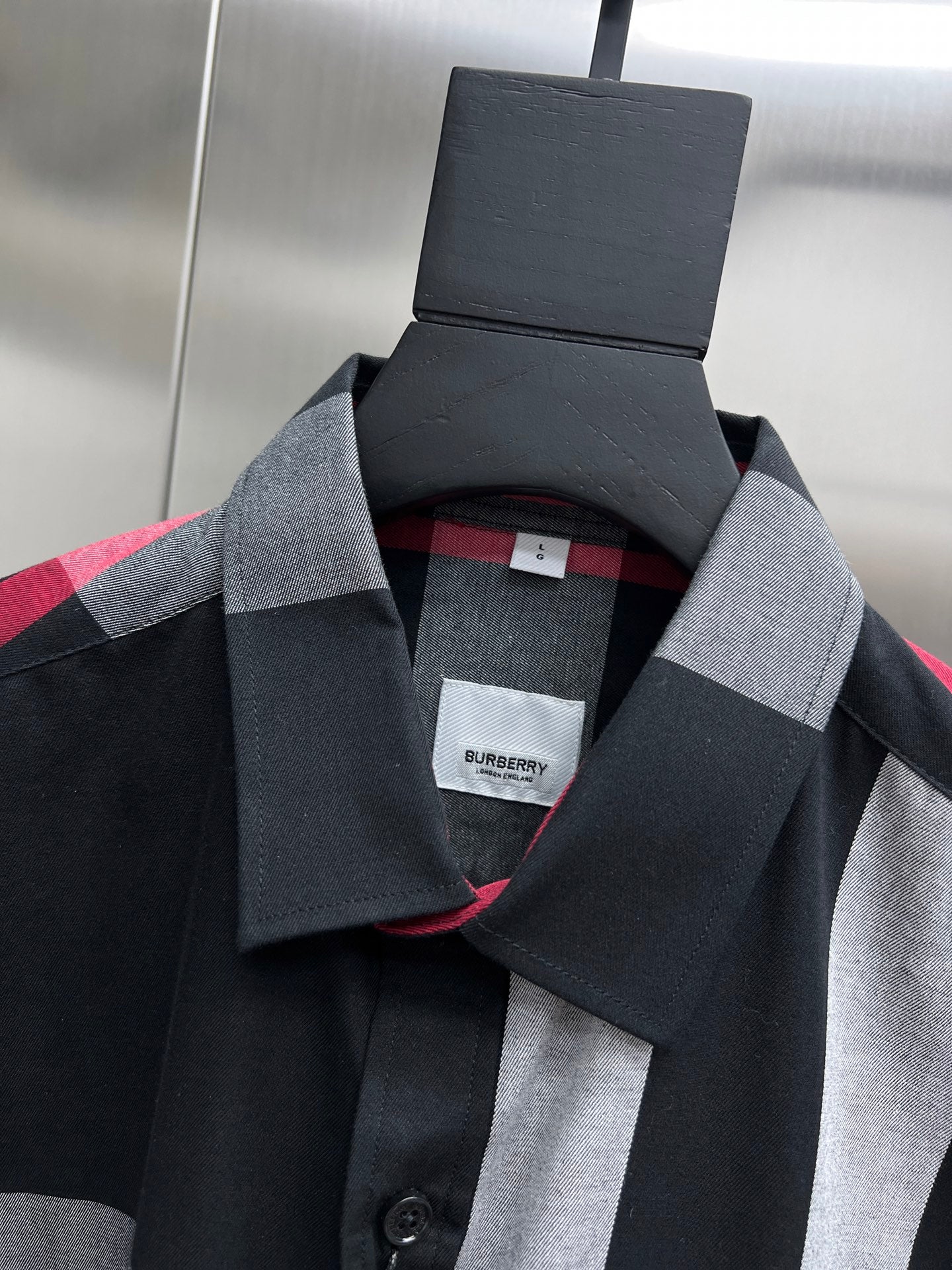 Plaid button-up shirt neckline with black and white checks and red trim