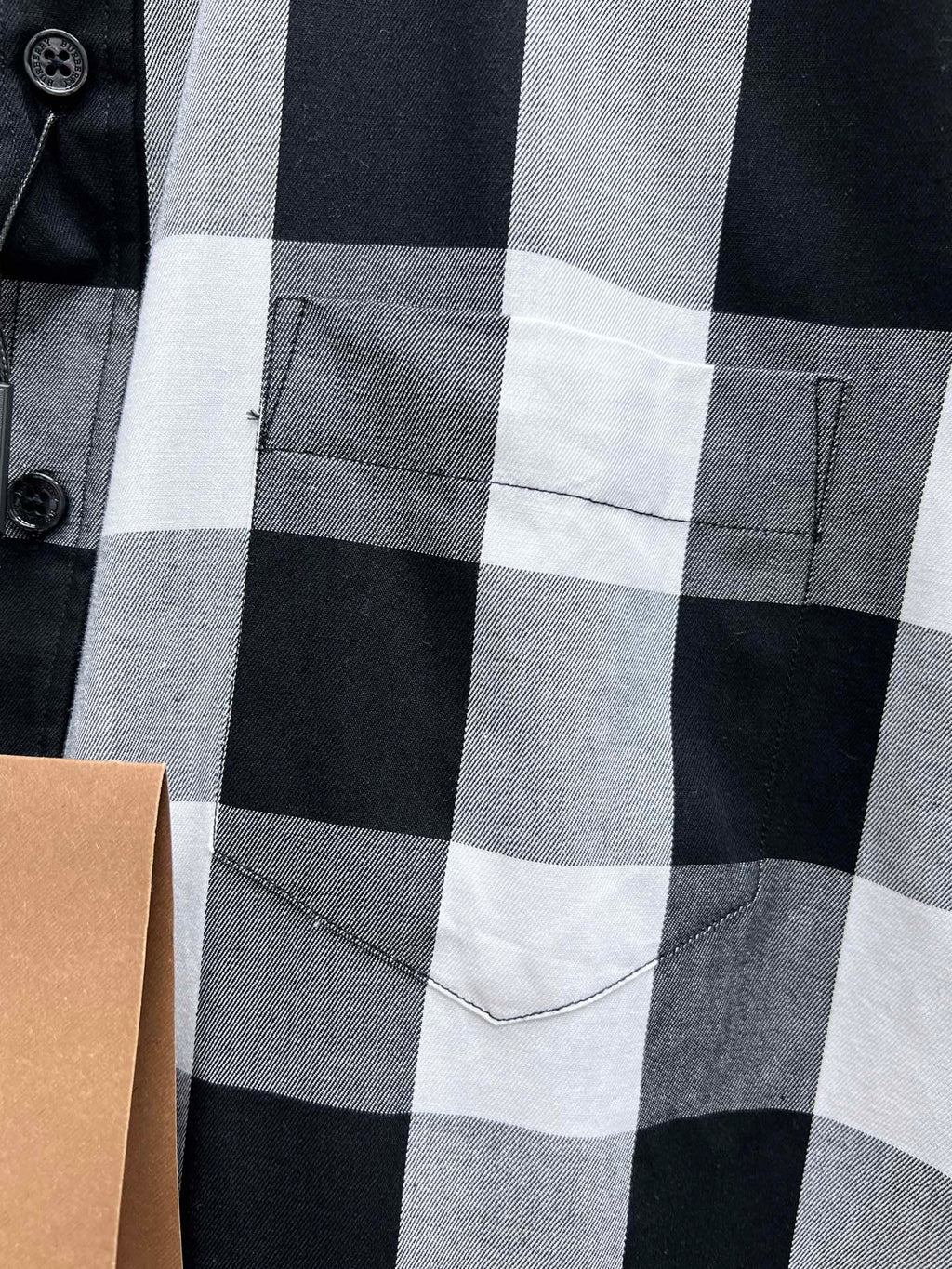Chest pocket on black, white, and gray plaid button-up shirt