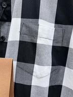 Chest pocket on black, white, and gray plaid button-up shirt