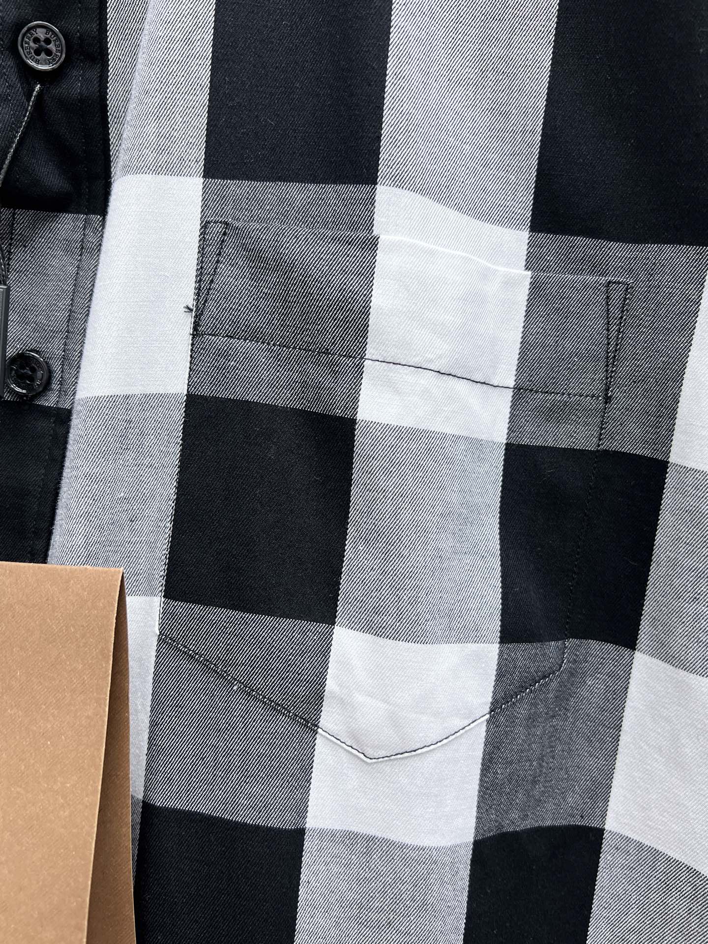 Chest pocket on black, white, and gray plaid button-up shirt