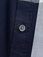 Burberry shirt button close-up on navy fabric with stitched placket
