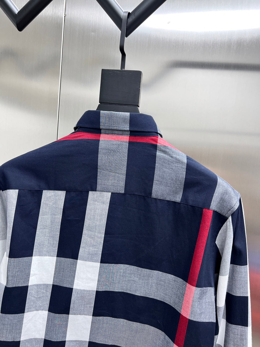 Long-sleeve plaid shirt on hanger with buttoned collar