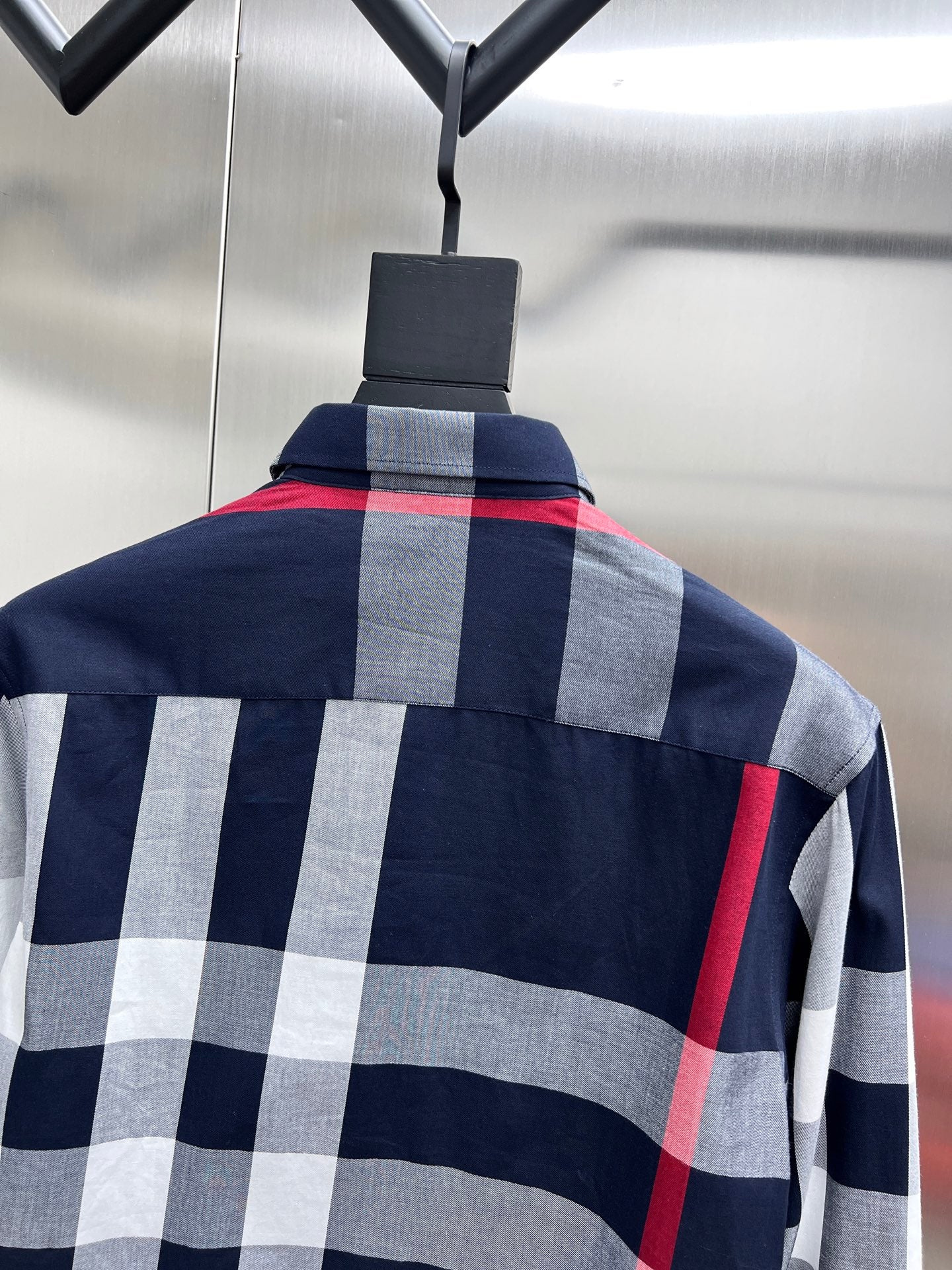 Long-sleeve plaid shirt on hanger with buttoned collar
