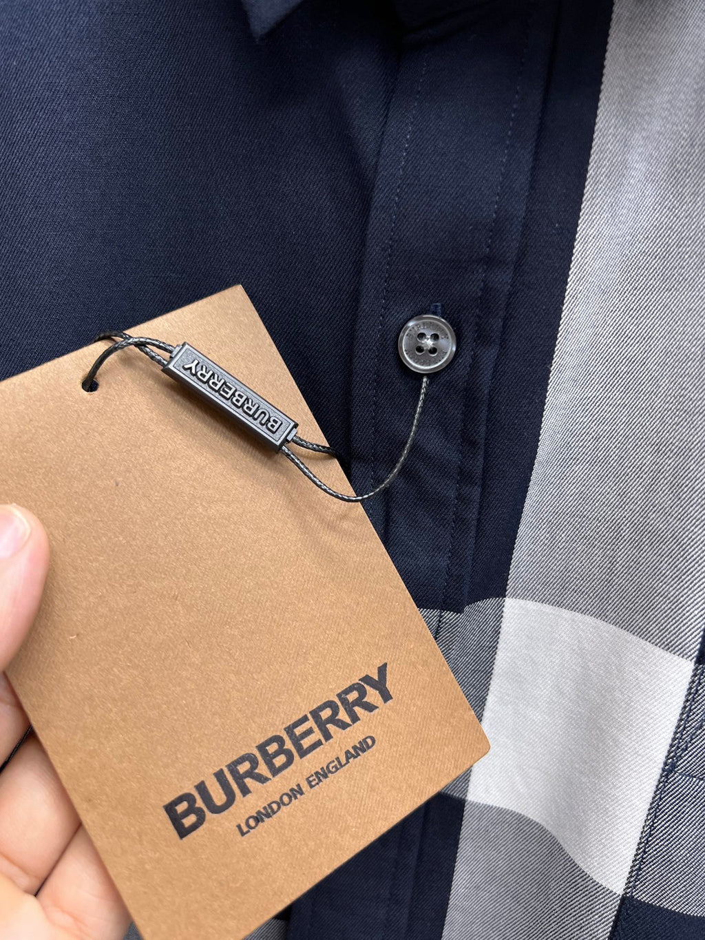 Burberry hang tag on plaid button-up shirt, navy and white checks