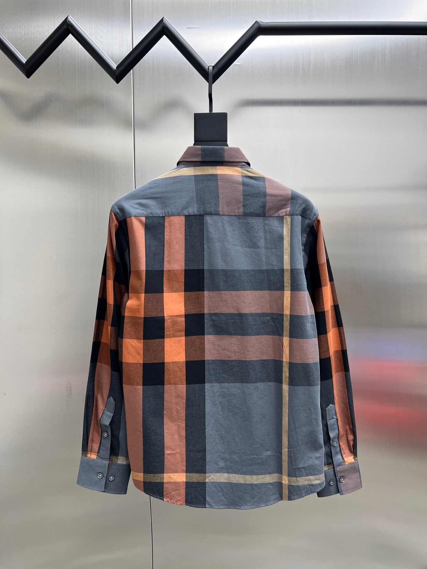 Back view of plaid long-sleeve button-up shirt with buttoned cuffs and collar