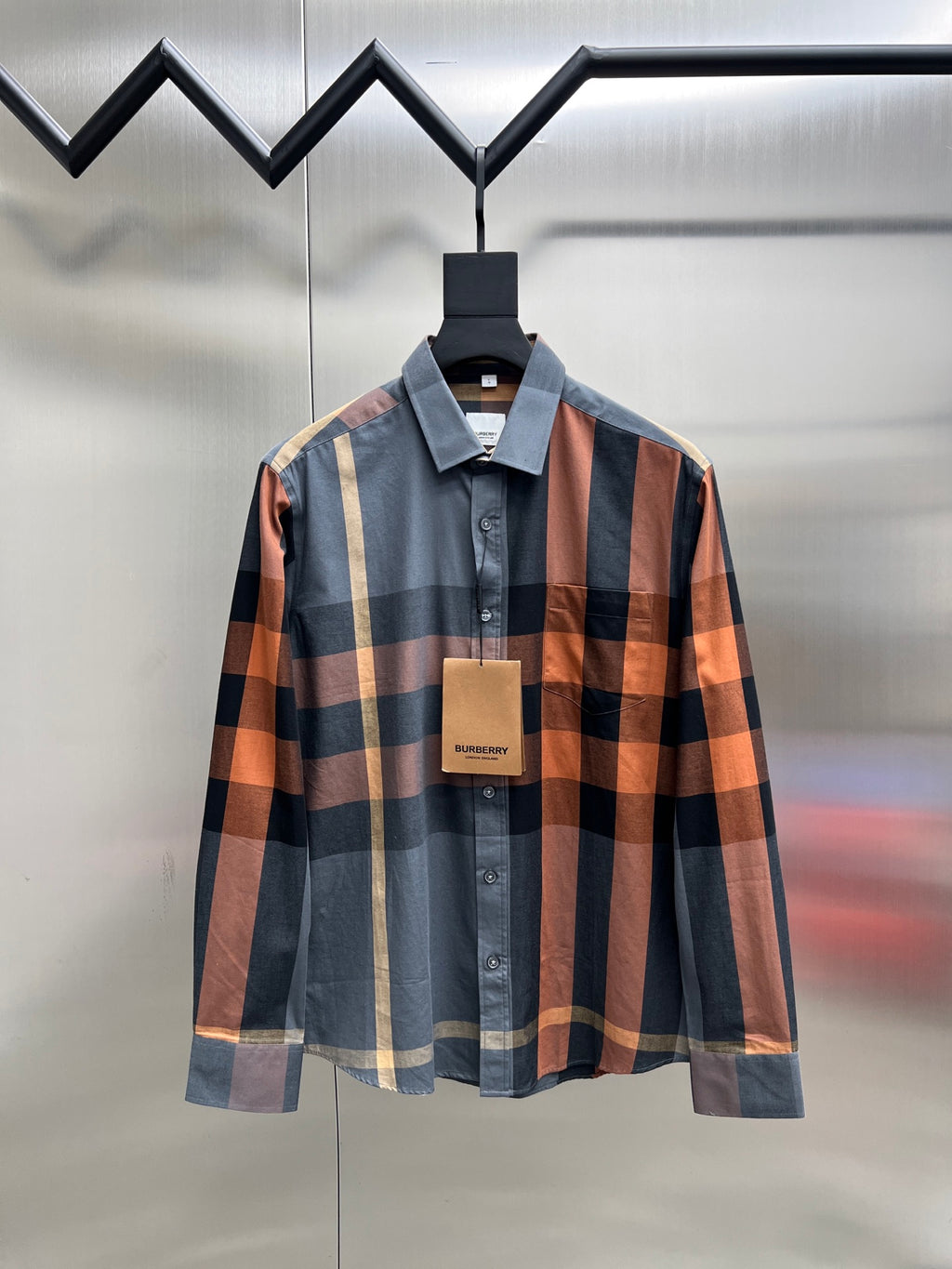 Plaid long-sleeve button-up shirt with collar, front button placket, and hanging tag