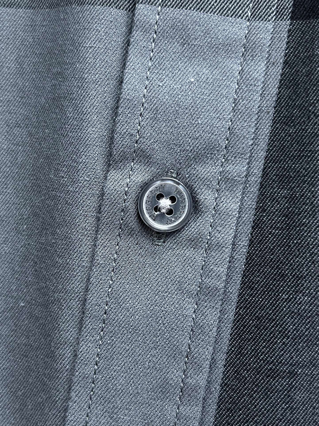 Plaid long-sleeve shirt close-up of front button and stitched placket