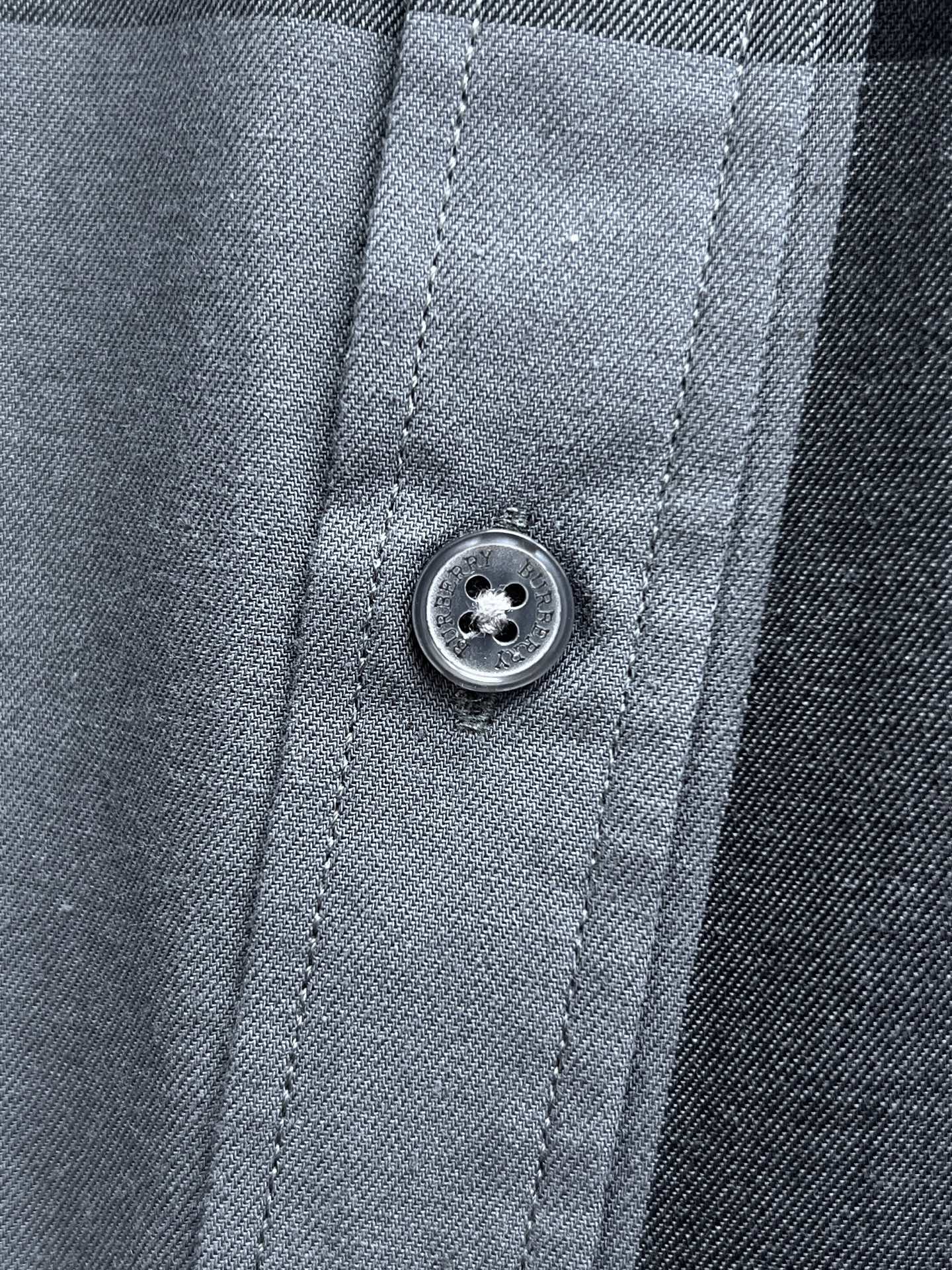 Plaid long-sleeve shirt close-up of front button and stitched placket