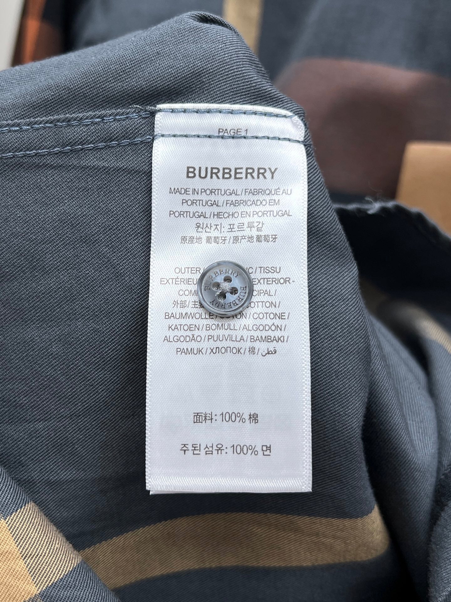 Burberry garment label on blue long-sleeve shirt, with fabric and care information