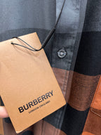 Plaid long-sleeve shirt detail with round button and attached Burberry London England tag