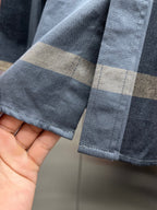 Long-sleeve shirt cuff with blue, beige plaid trim and buttoned sleeve end