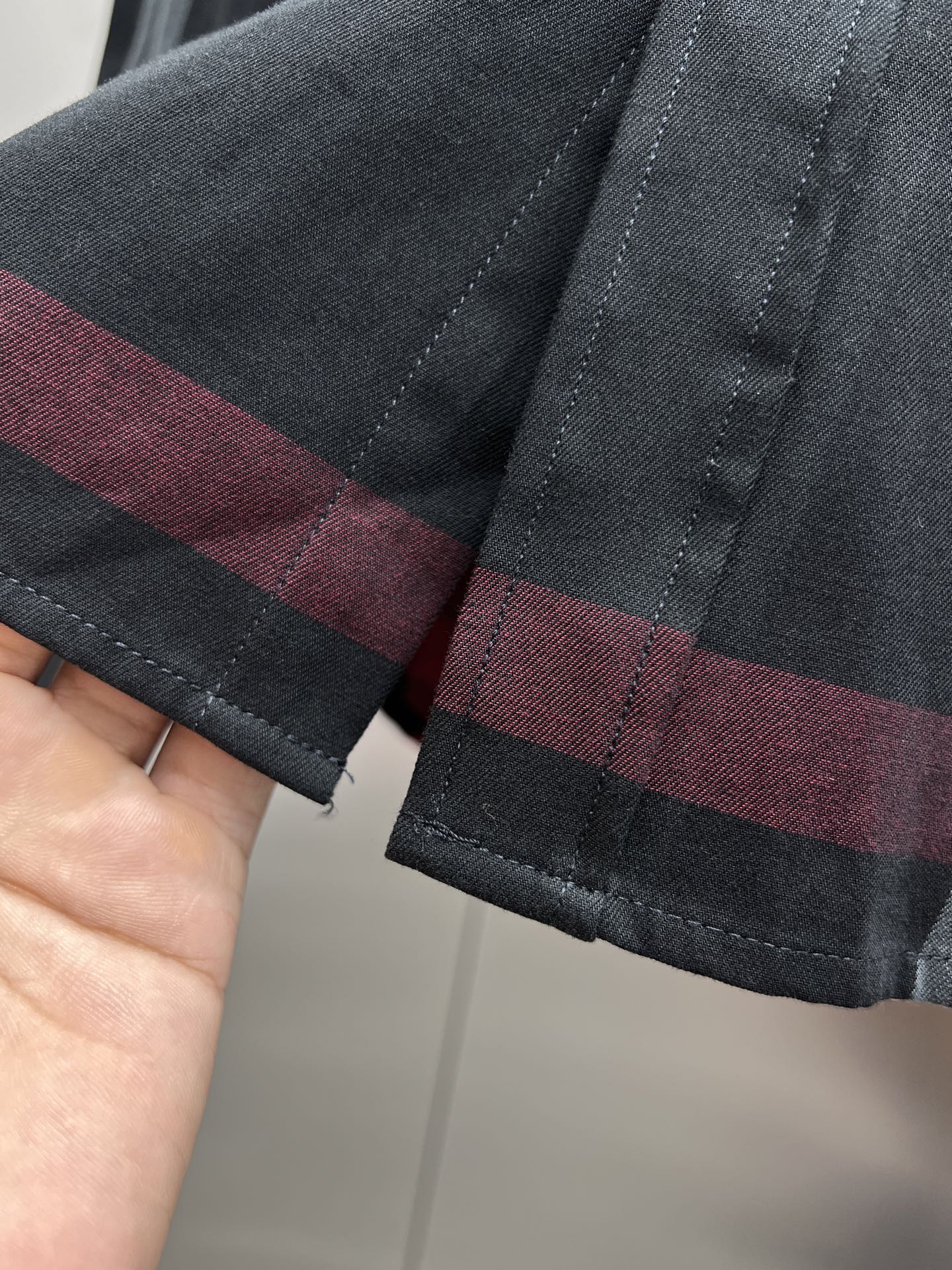 Dark plaid long-sleeve shirt cuff with button placket and stitched hem