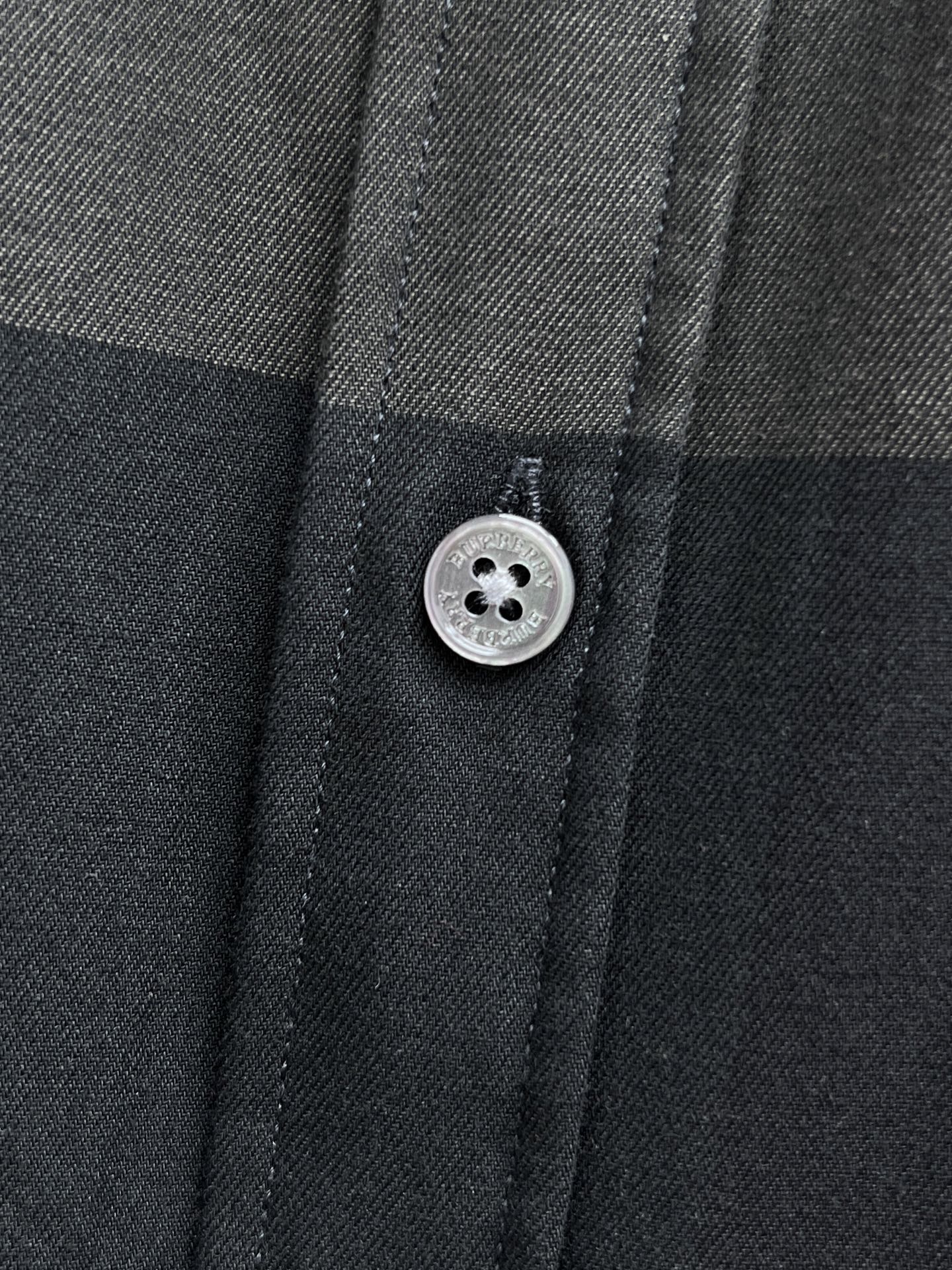 Burberry plaid button-up shirt button close-up, dark gray fabric