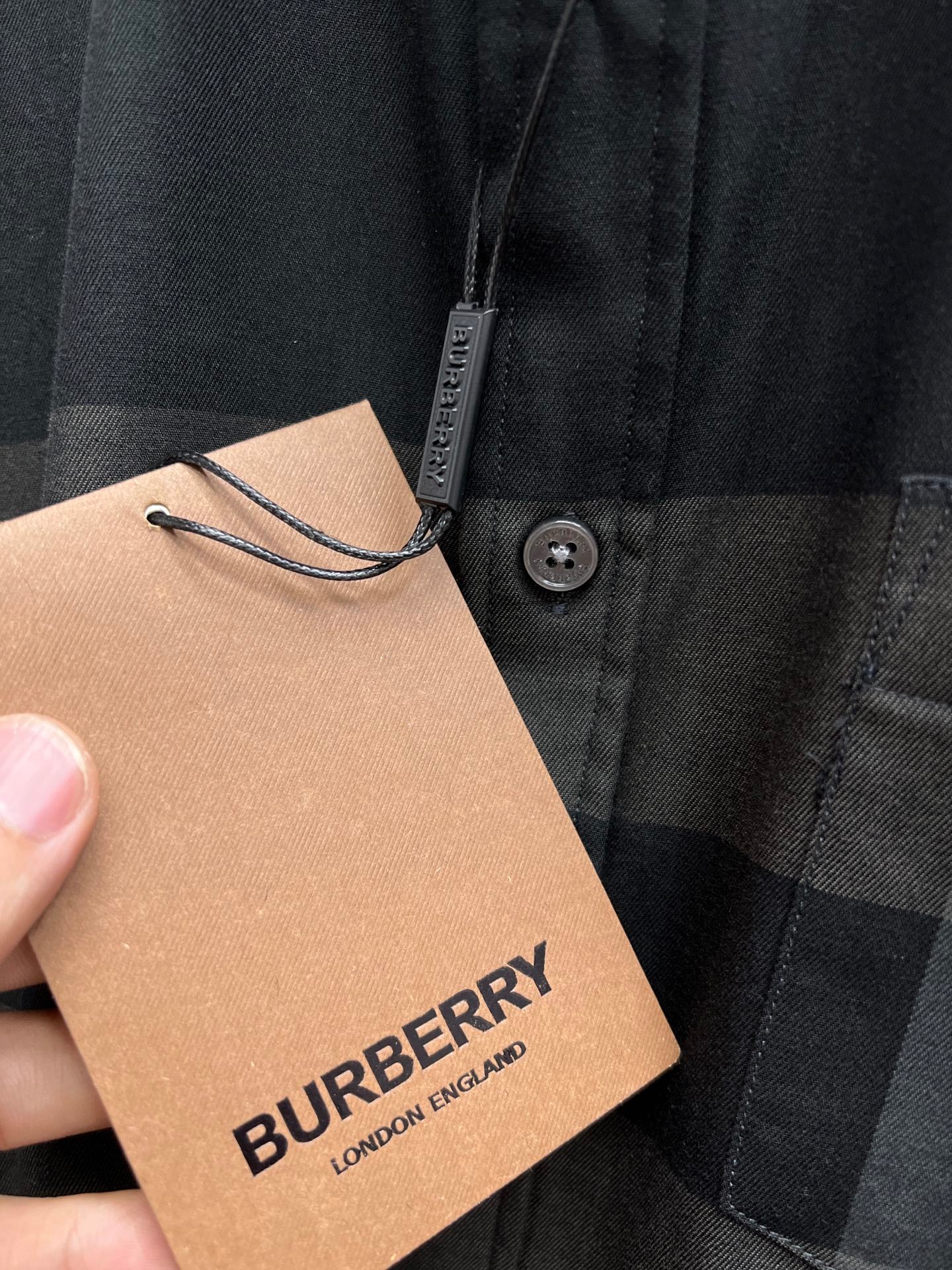 Burberry plaid button-up shirt with button placket, shown with hanging brand tag