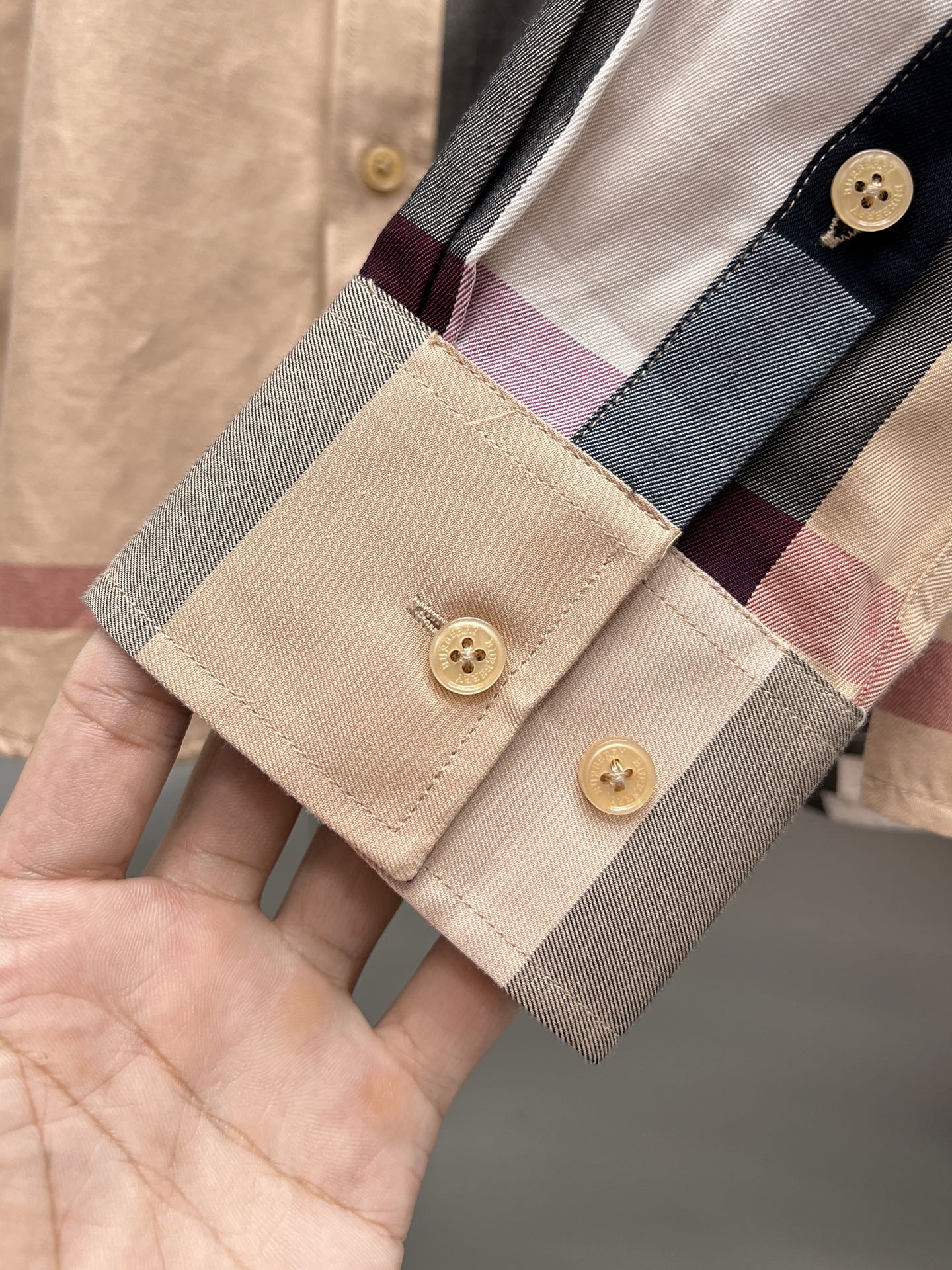 Plaid shirt cuff with two buttons, beige and burgundy and gray checks