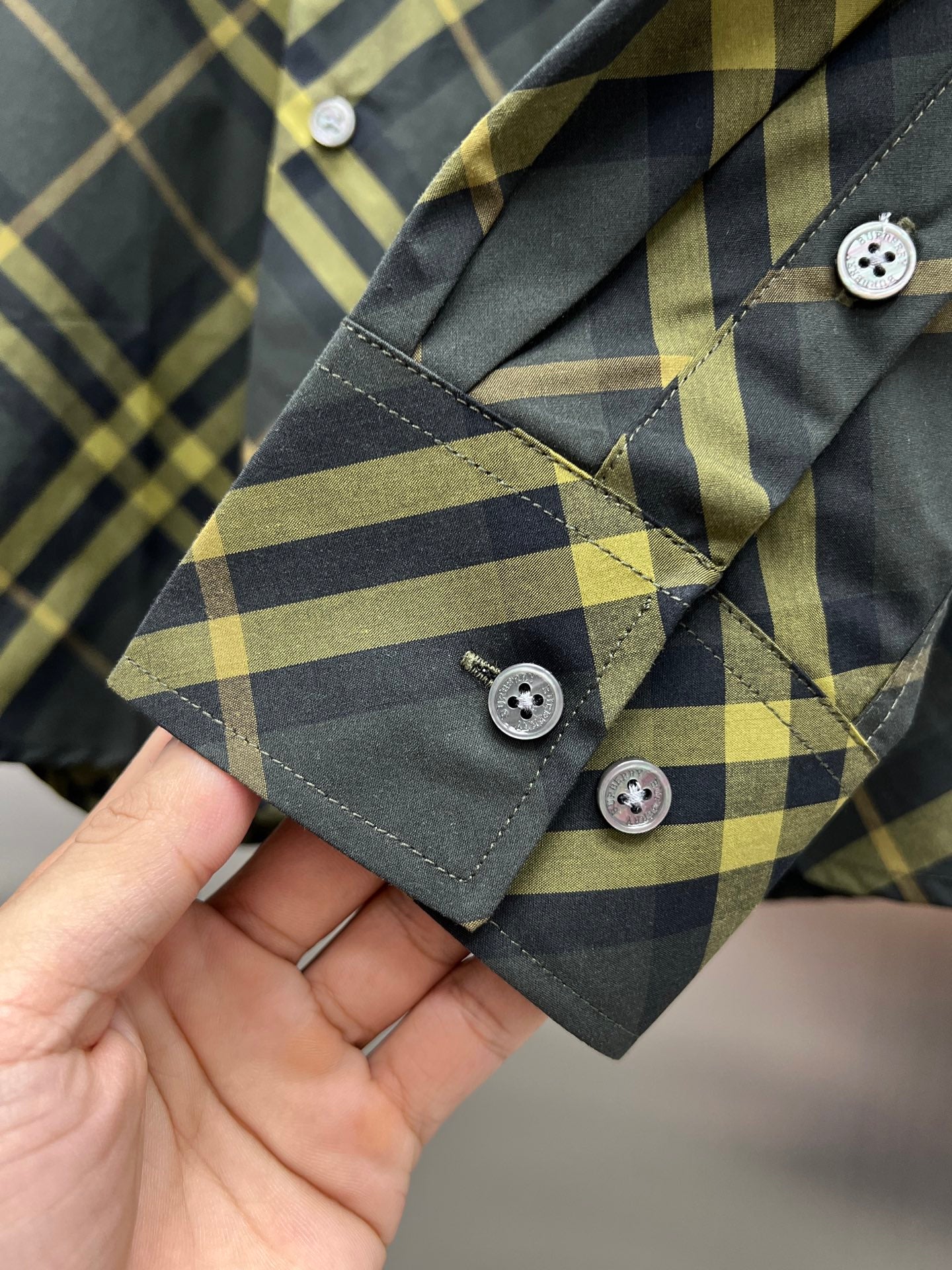 Long-sleeve shirt cuff with buttons, dark green and yellow plaid