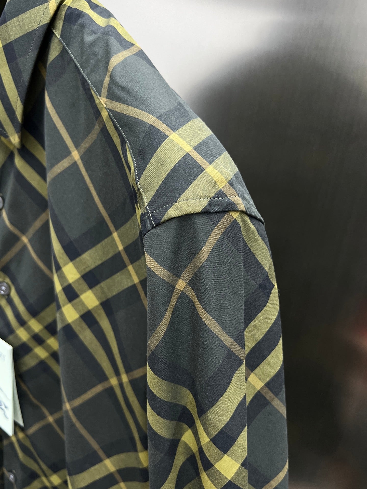 Plaid shirt sleeve close-up with textured fabric and button cuff
