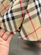Burberry plaid shirt fabric close-up with beige, black, white, and red lines