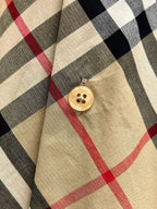 Burberry plaid shirt with round gold button on beige, black, and red pattern