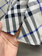 Burberry plaid shirt fabric fold in blue, black, and white check pattern