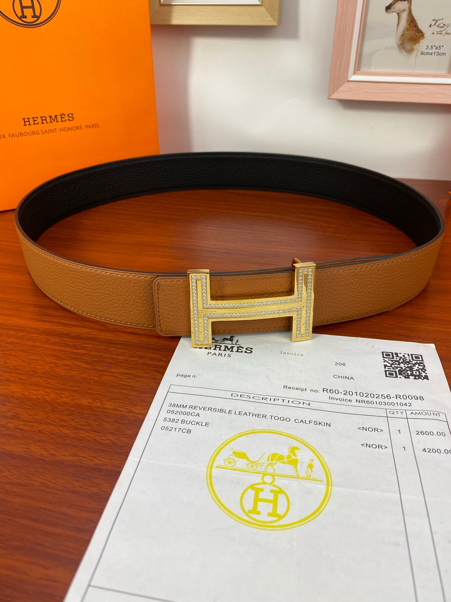 Reversible leather belt with tan strap and gold-tone H buckle, black underside
