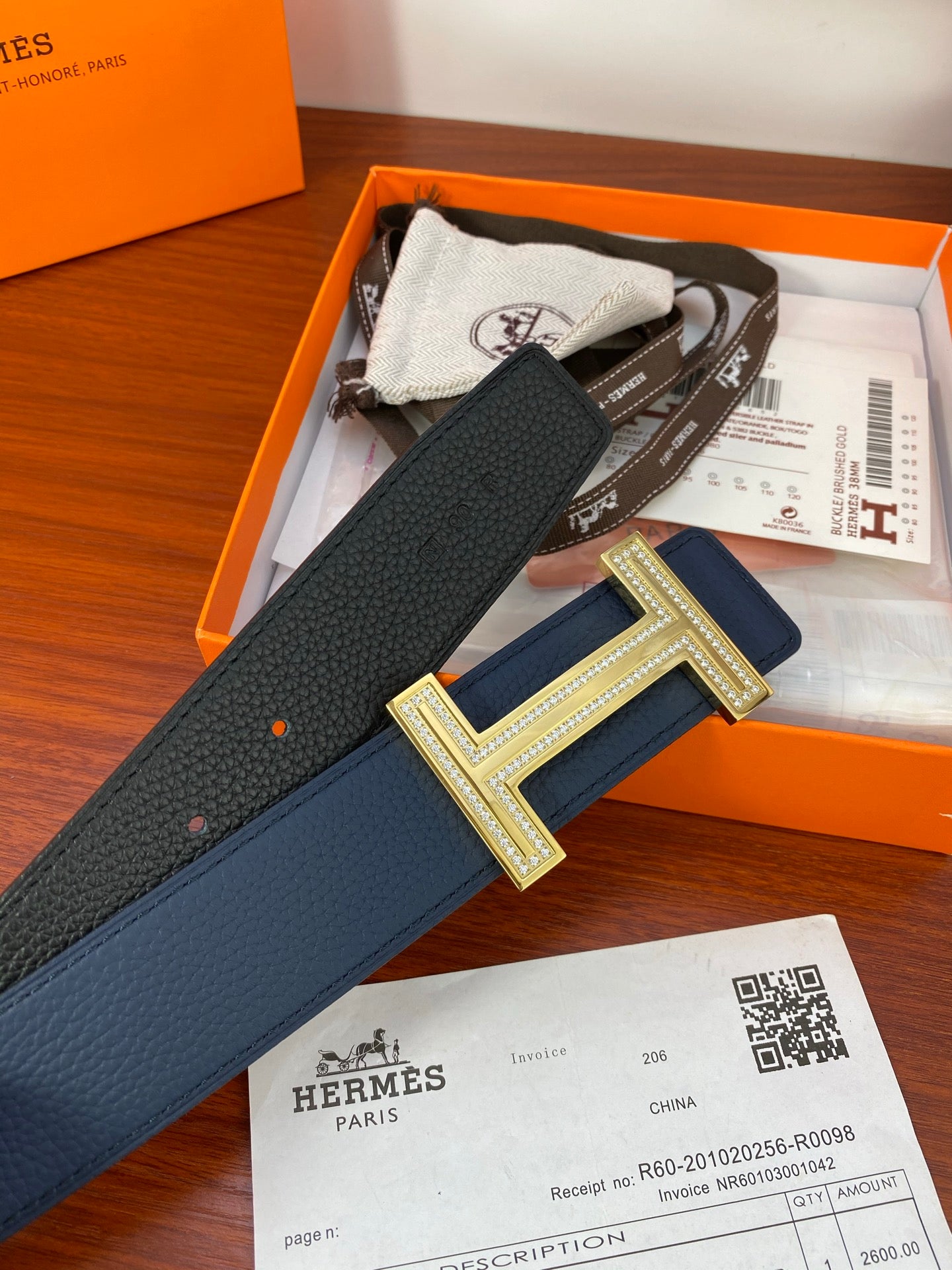 Blue leather belt with gold H buckle, showing strap length and keeper.