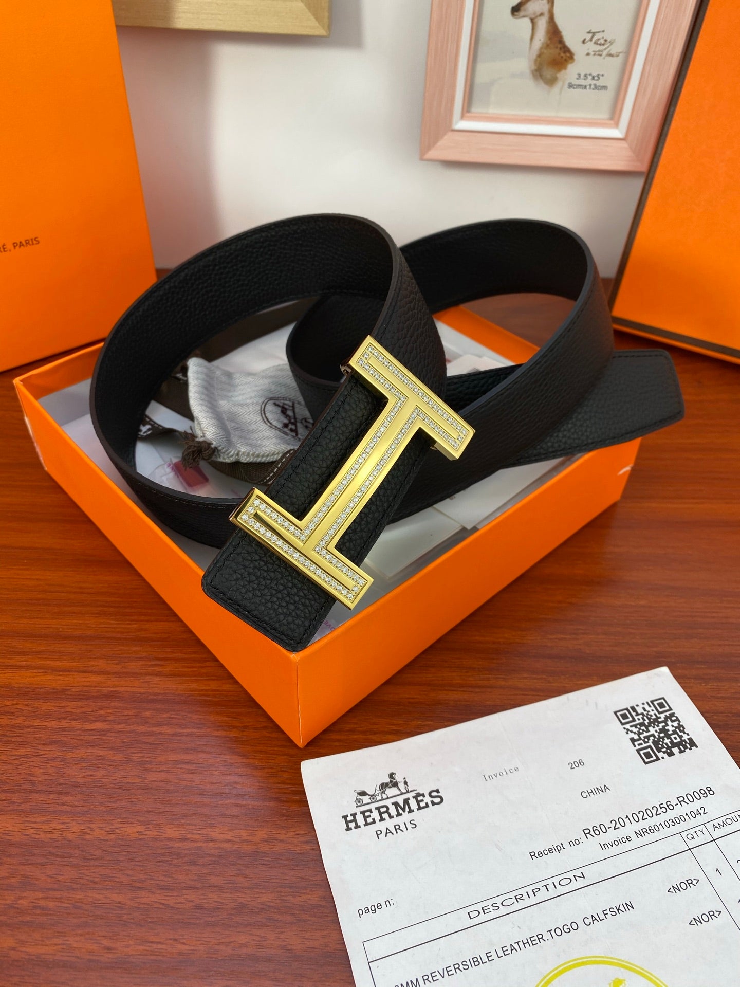 Black leather belt with gold-tone H buckle, on orange presentation box