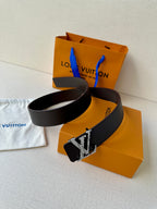 Louis Vuitton belt coiled with dark strap and silver-tone LV buckle detail