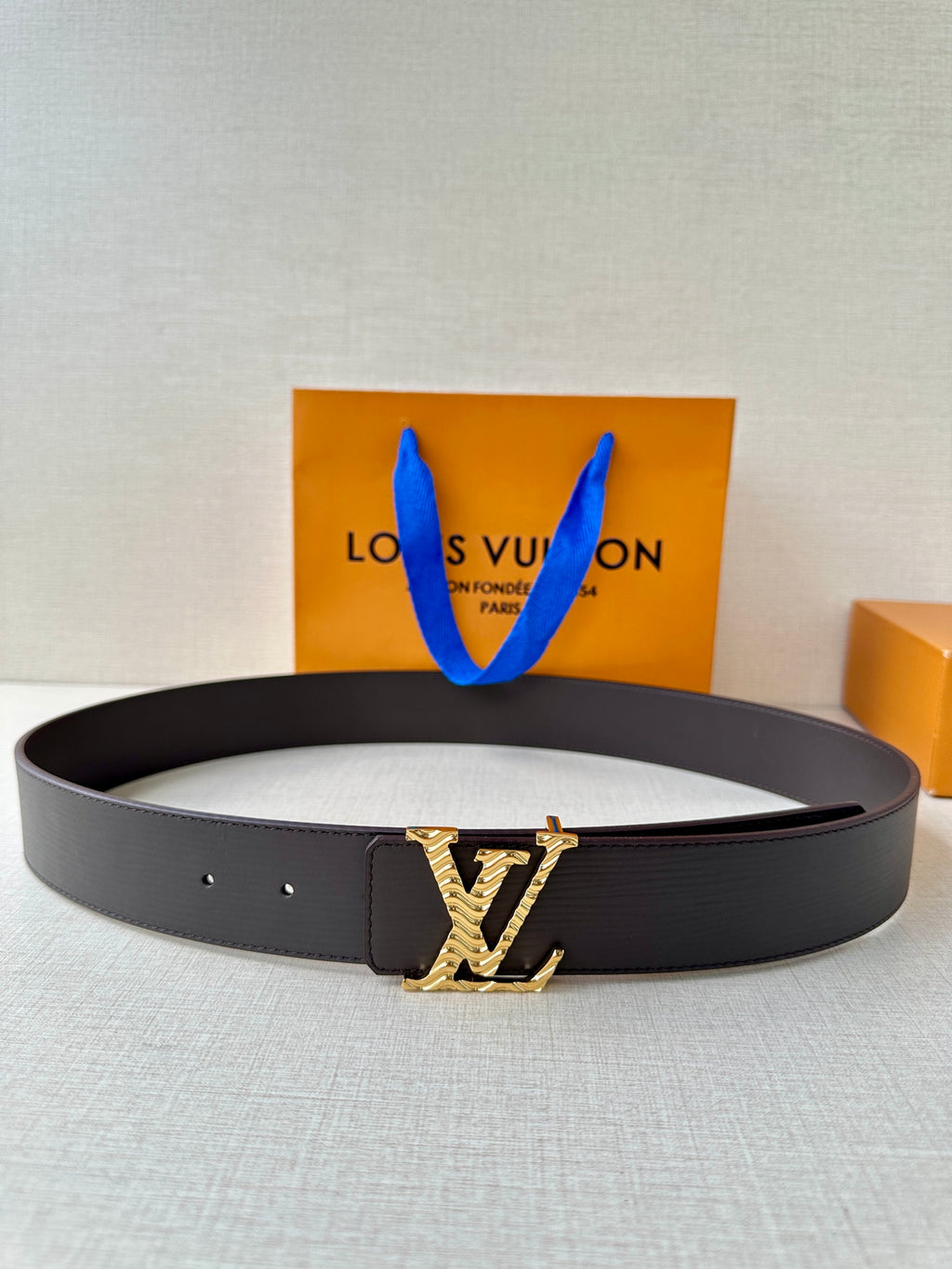 Louis Vuitton belt with dark leather strap and gold-tone monogram buckle