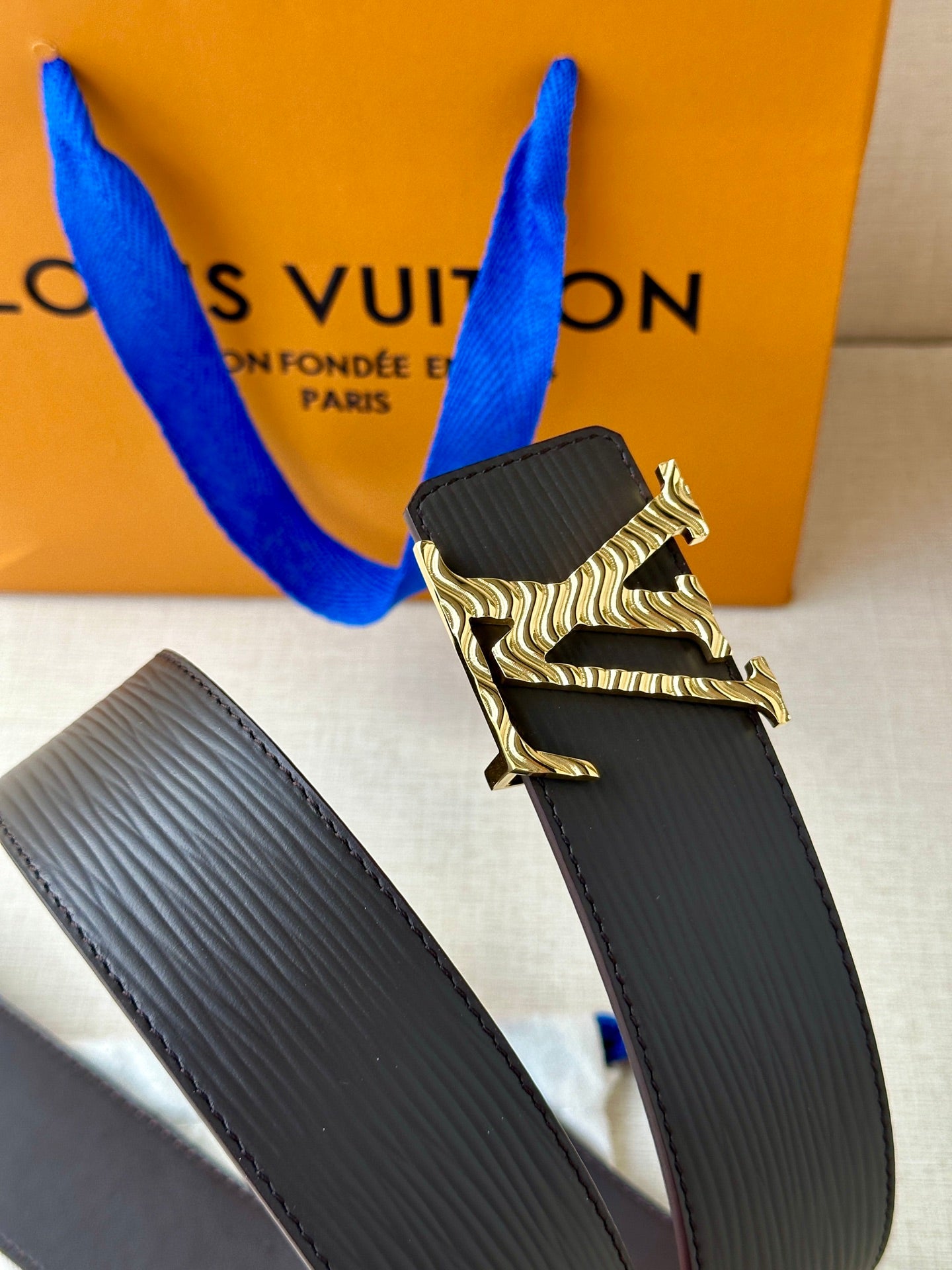 Louis Vuitton belt with dark textured strap and silver-tone LV buckle
