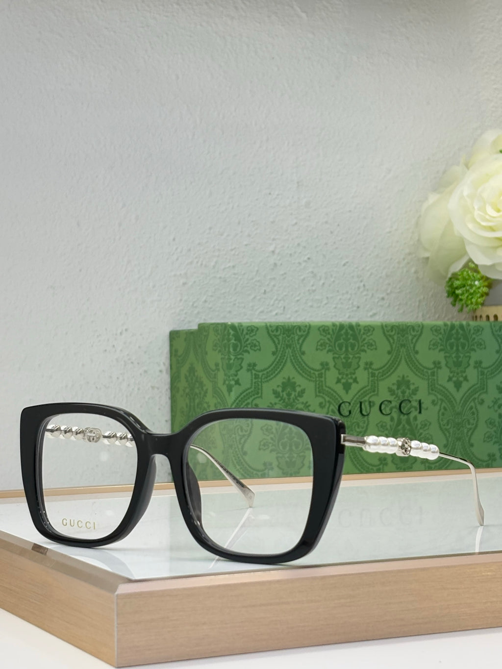Gucci glasses with tinted lenses, black square frames, and pearl-bead temple detail