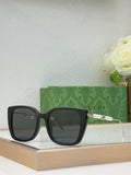 Gucci glasses with dark lenses, black square frames, and pearl-bead temple detail