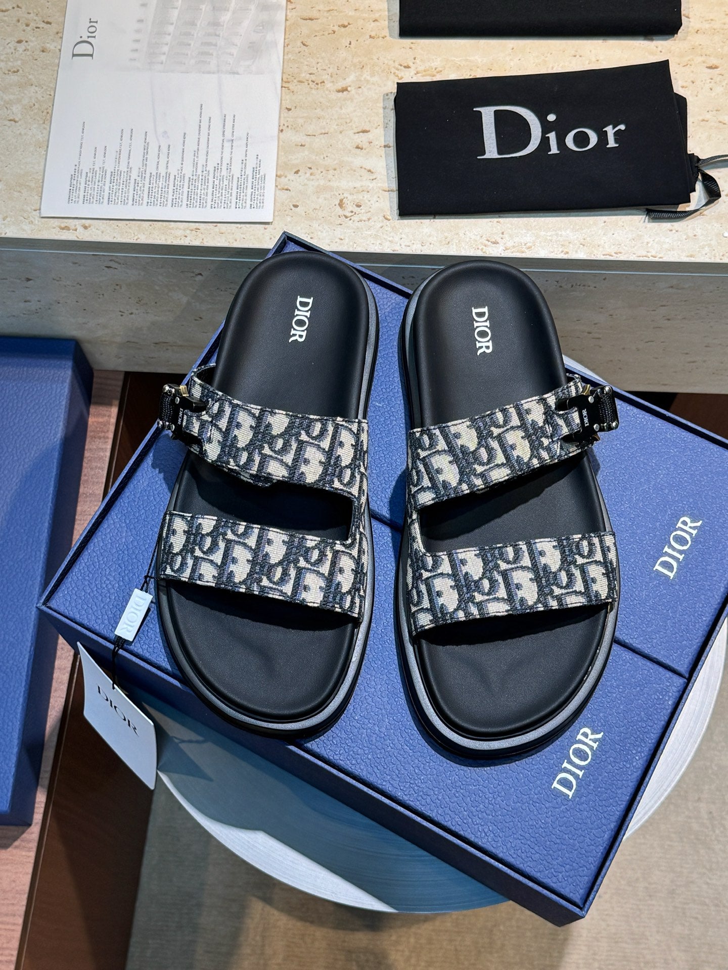 Unisex Dior slide sandals with black straps and Dior monogram print band