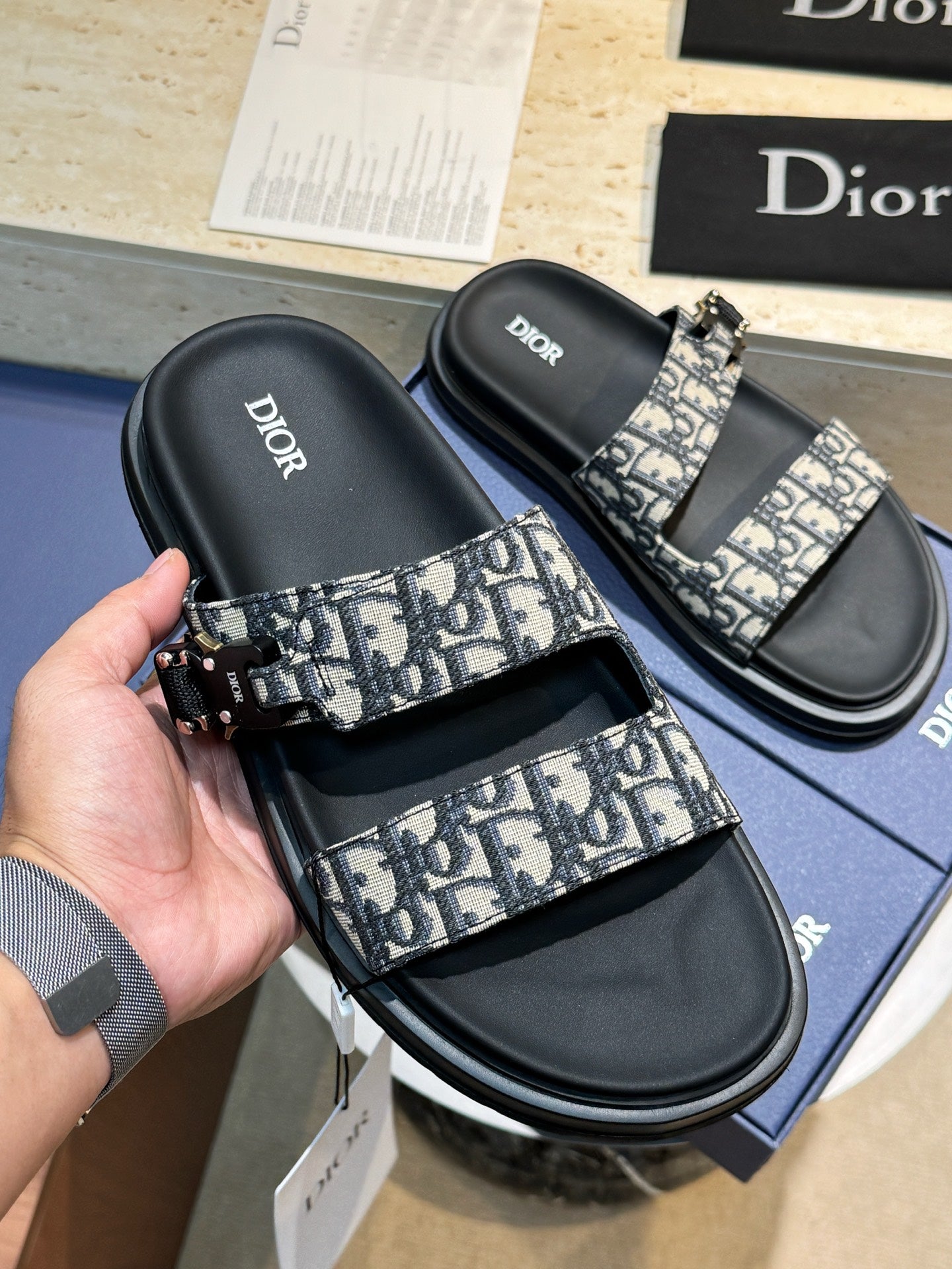 Unisex Dior slide sandals with black leather straps and Dior monogram print buckle