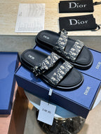 Unisex Dior slide sandals with black leather straps and all-over Dior monogram print