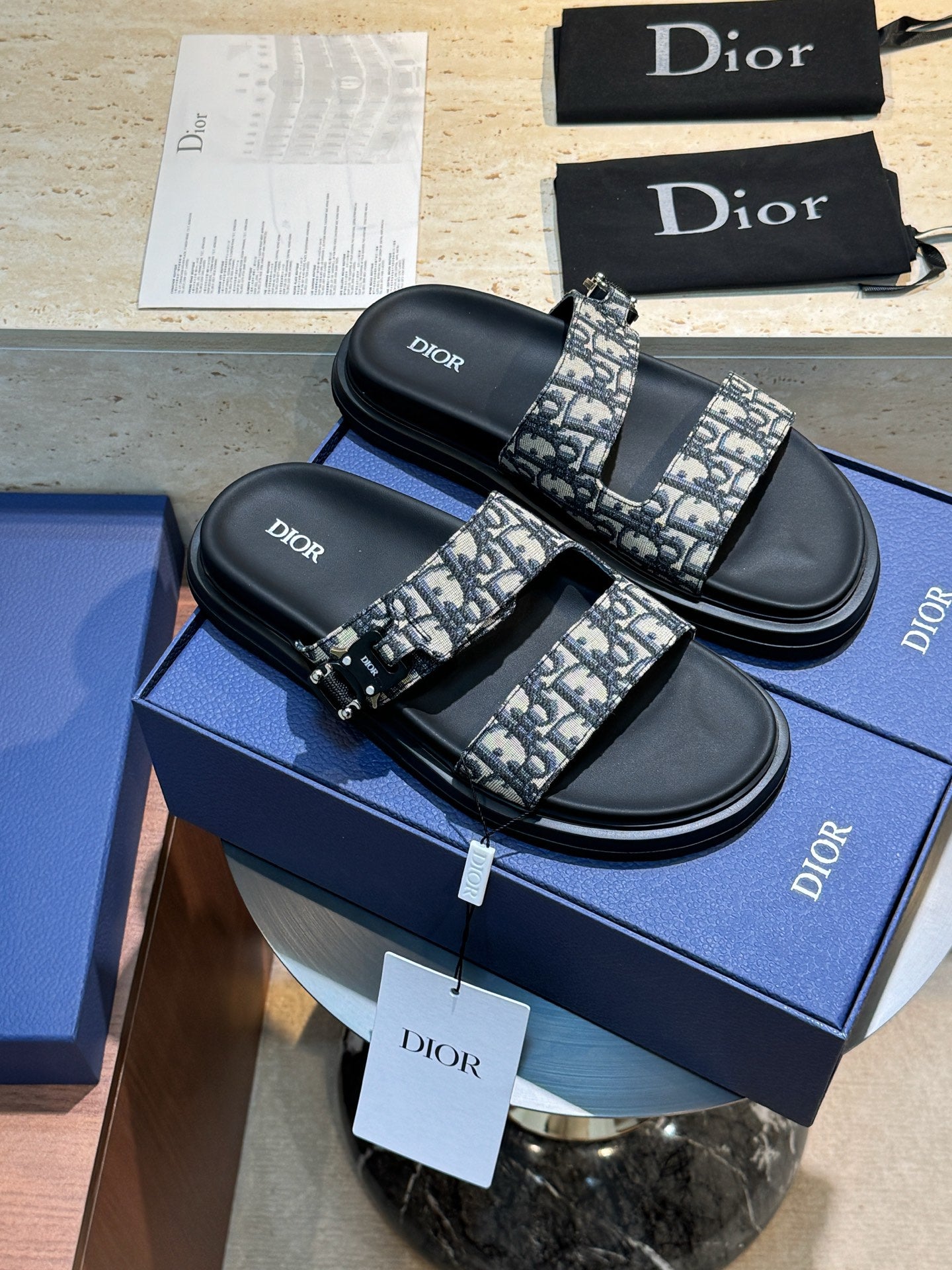 Unisex Dior slide sandals with black leather straps and all-over Dior monogram print