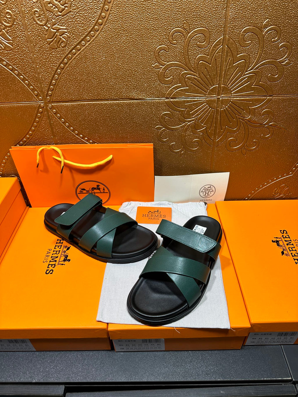Hermes slide sandals featuring teal green straps over black cushioned footbeds