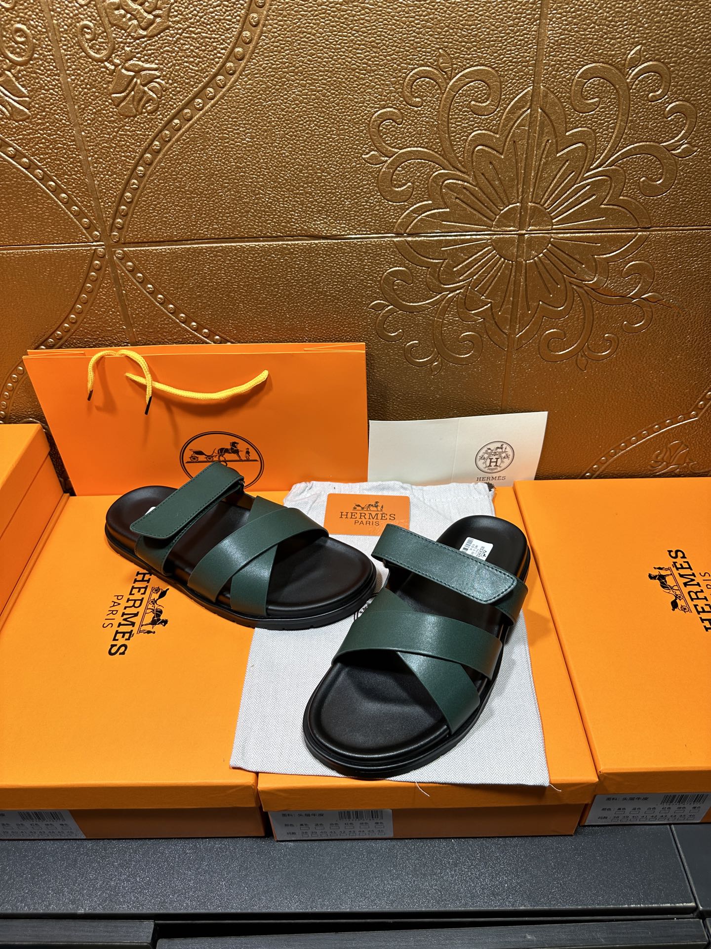 Hermes slide sandals featuring teal green straps over black cushioned footbeds