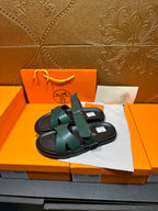 Hermes teal slide sandals with two wide crossing straps and black footbed
