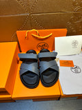Hermes slide sandals with navy crossover straps and black footbeds, paired